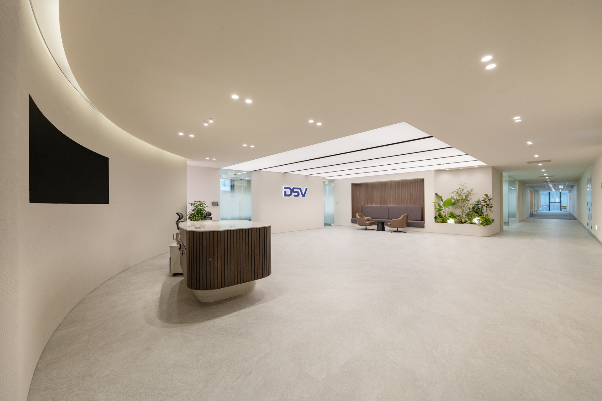 DSV 디에스브이에어앤씨 DSV Air & Sea 오피스 인테리어 - 시드나인 SIDnine 시공, 곡선형 리셉션 데스크와 DSV 로고월, 대기 라운지가 연결된 로비 공간