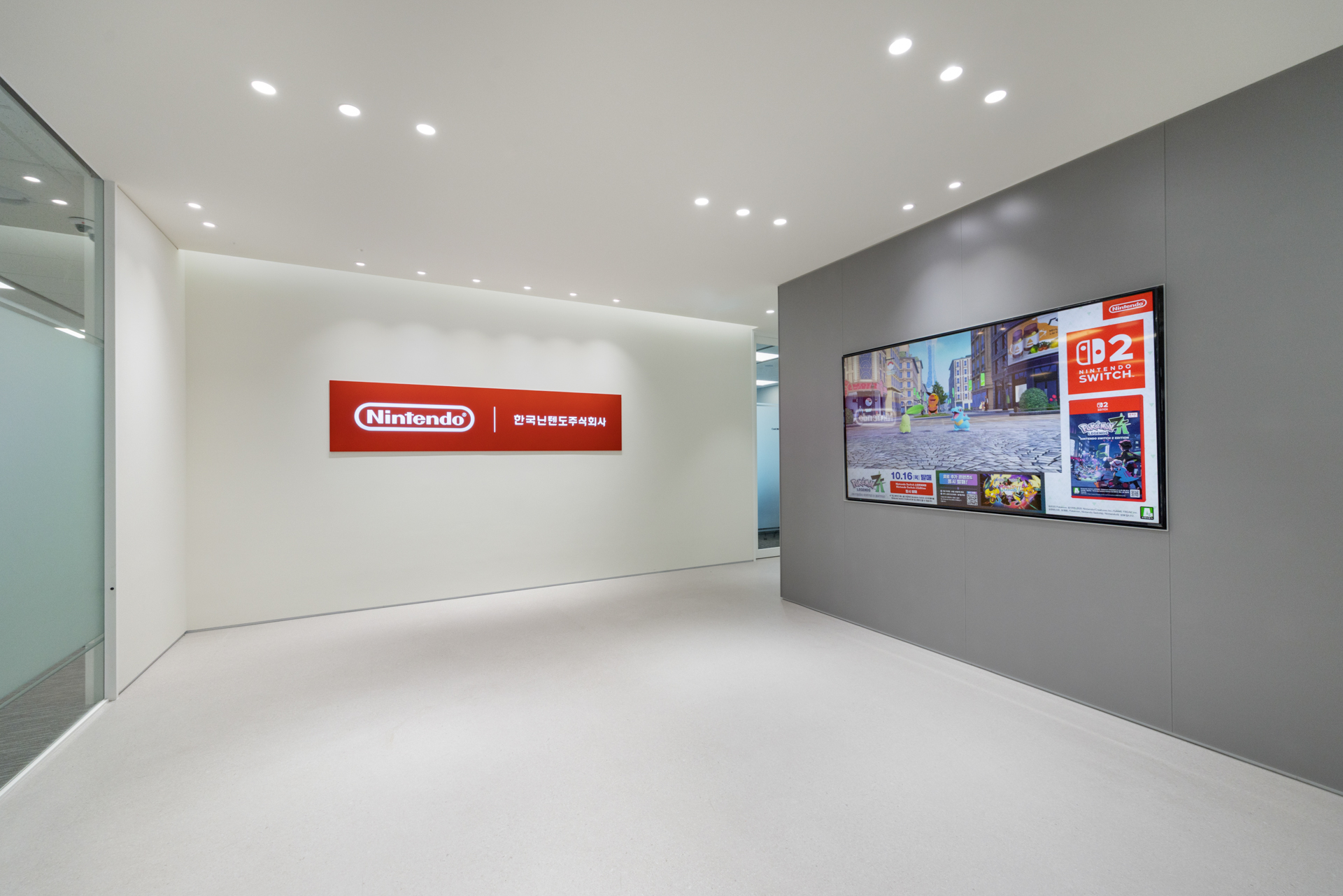 한국닌텐도(Nintendo Korea) 오피스 로고월과 디지털 디스플레이가 배치된 미니멀한 입구 공간, 시드나인(SIDnine) 시공 office interior