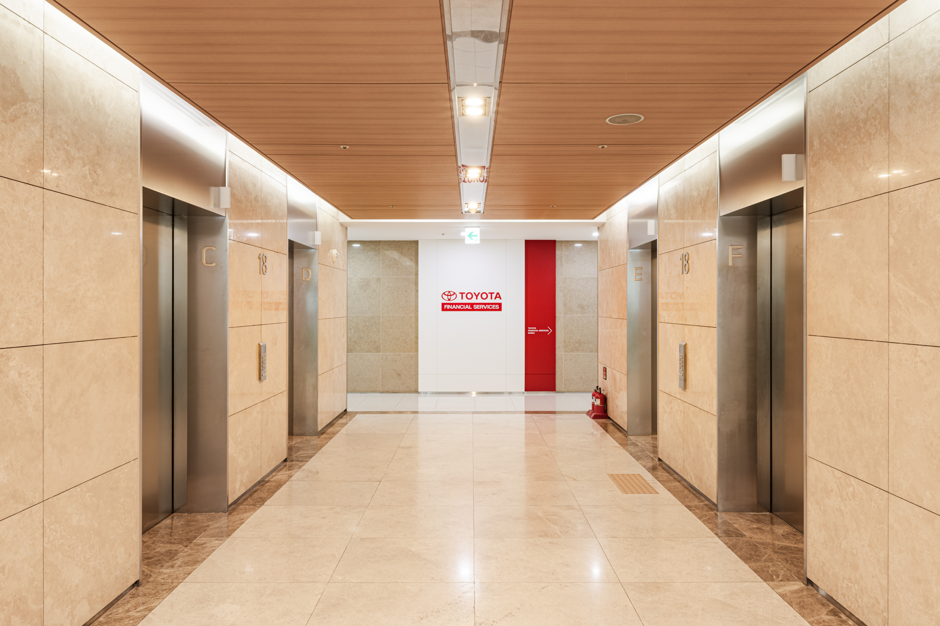 토요타파이낸셜서비스코리아(Toyota Financial Services Korea) 오피스 층 로비 공간, 대리석 마감의 엘리베이터 홀 중앙에서 본 입구 전경. 시드나인(SIDnine)이 설계 및 시공한 오피스 인테리어.