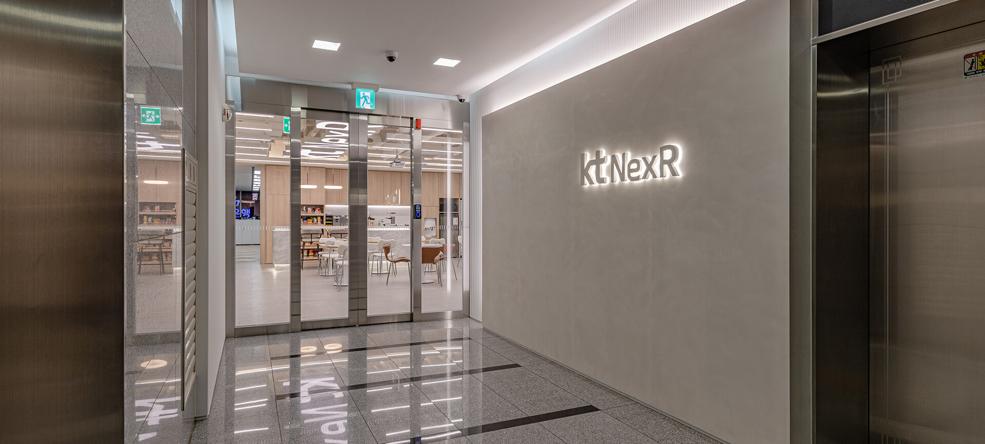 케이티넥스알 KT NexR 로고월 입구 엘리베이터홀 후면발광로고 스카시 로고 스페셜페인트 루버 스팟 간접 조명 모던 현대적 심플 차분함