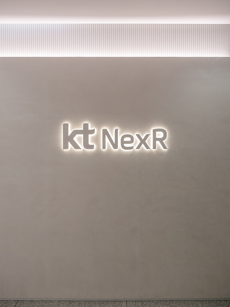 케이티넥스알 KT NexR 로고월 입구 엘리베이터홀 후면발광로고 스카시 로고 스페셜페인트 루버 스팟 간접 조명 모던 현대적 심플 차분함